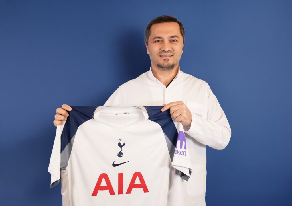 Elithair und Tottenham Hotspur: Eine internationale Kooperation mit Signalwirkung Bild zeigt, wie Dr. Abdulaziz Balwi ein Trikot des Premiere League Klubs Tottenham Hotspur in beiden Hände hält
